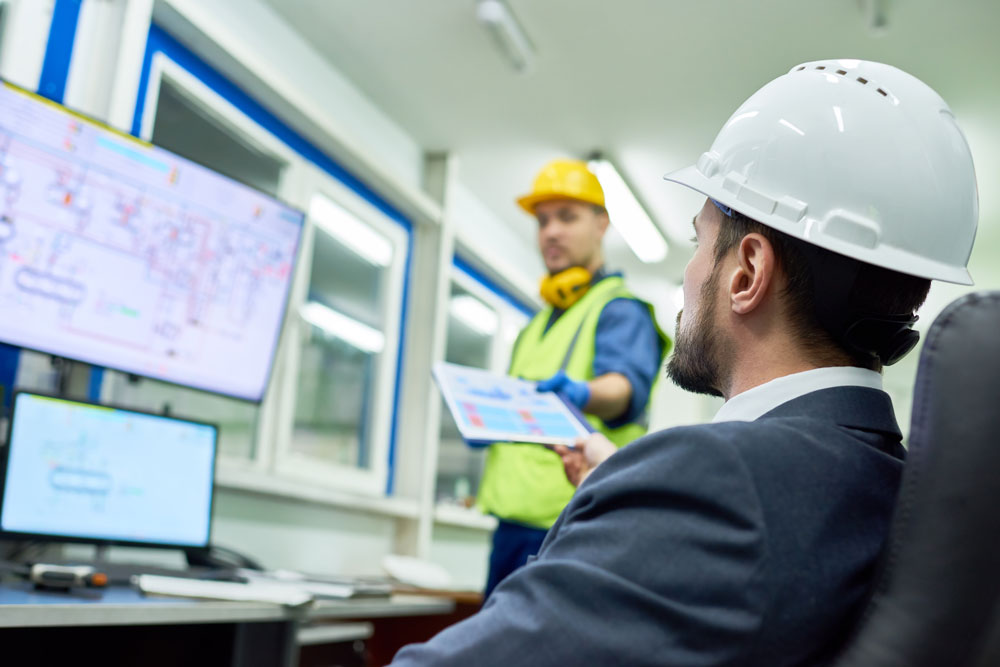 Businessman overseeing machine data collection of plant production