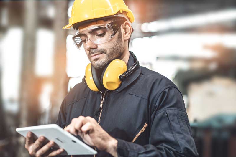 Factory worker reviewing OEE reporting