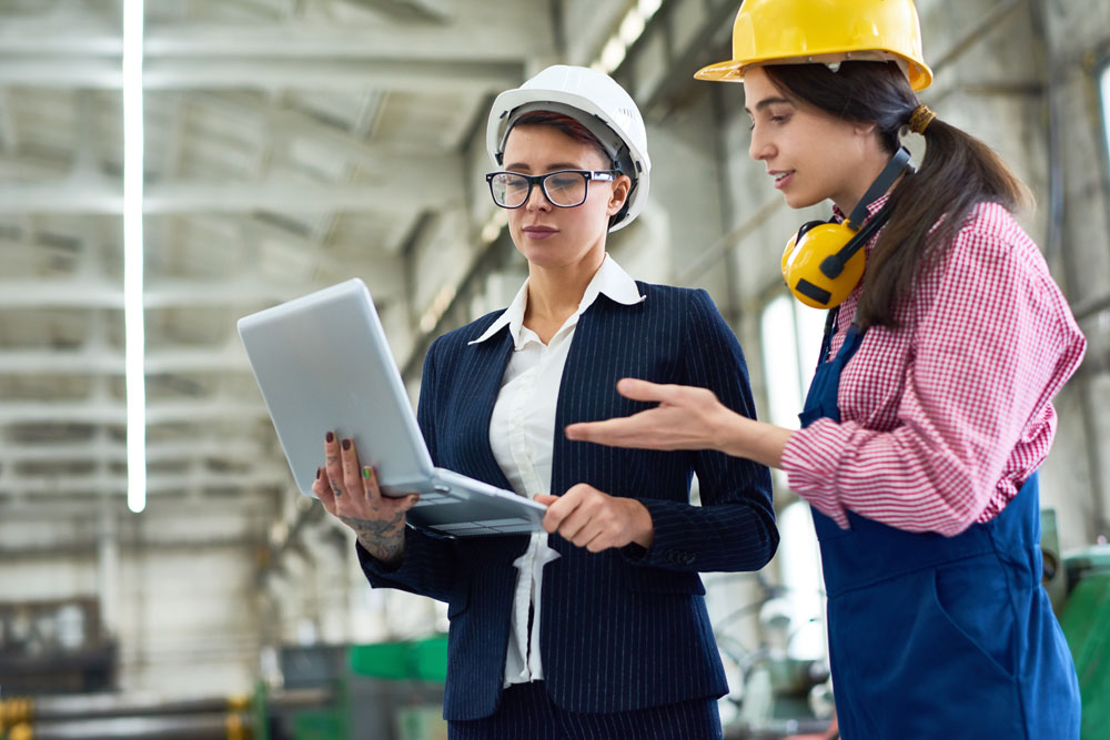 Female staff members taking inventory of production with machine data collection