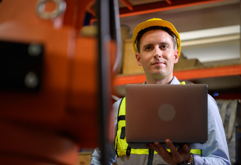 Male staff member using software and data to learn how to reduce manufacturing costs